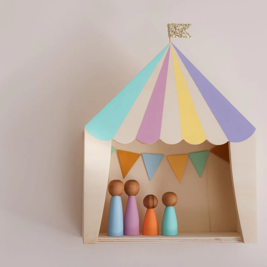Estantería de madera con forma de carpa de circo pastel y cuatro figuras de madera